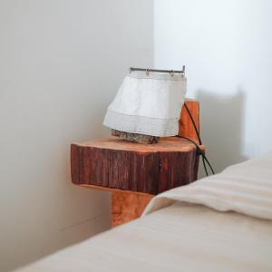 a lamp on a wooden table next to a bed at Masseria La Fiorita in Matera