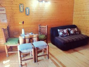 Cette chambre comprend une table, une chaise et un canapé. dans l'établissement Apartamentos Rurales El Rincón del Jerte, à Rebollar