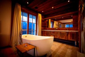 a large bathroom with a tub and a large window at Chalet Bergmueller in Schladming