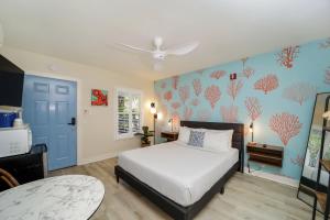 um quarto com uma cama e uma parede azul em Tranquillity Guest House em Key West