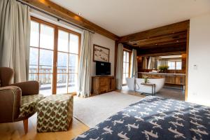 a bedroom with a bed and a tub and a television at Chalet Bergmueller in Schladming