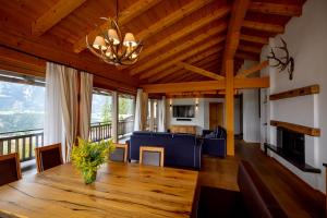 a living room with a wooden ceiling and a dining room at Chalet Bergmueller in Schladming
