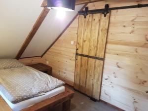 a bedroom with a bed and a wooden wall at Chalupa Řeka - Na samotě u lesa in Řeka