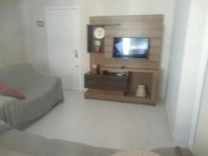 Habitación con cama y TV en la pared. en Apto Cond.Ilha de Majorca, en Bombinhas