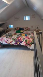 a bedroom with a large bed in a attic at Charmante maisonnette au cœur de la campagne in Pourrain