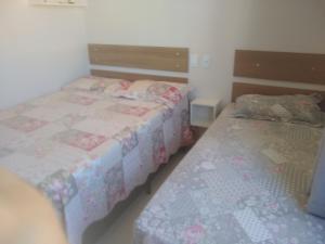 2 camas en una habitación pequeña con 2 camas sidx sidx sidx en Apto Cond.Ilha de Majorca, en Bombinhas