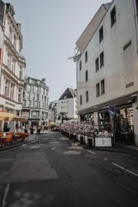 une rue de la ville avec des tables, des chaises et des bâtiments dans l'établissement Boutique Hotel Cologne, à Cologne