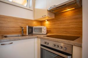 a kitchen with a sink and a microwave at Apartment Central Fulpmes + free parking spot in Fulpmes