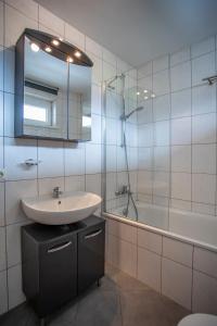 Apartment Central Fulpmes + free parking spot في فولبميس: حمام مع حوض وحوض ومرآة