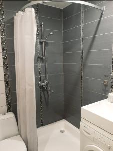 a bathroom with a shower with a toilet and a sink at New! Cozy Apartment with Free guarded parking in Rīga