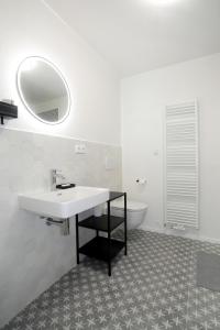 Baño blanco con lavabo y bañera en Apartmán Frolkova Strážnice, en Strážnice