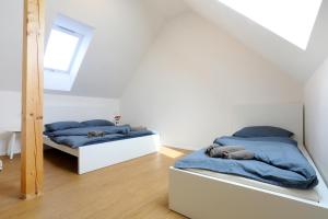2 camas en una habitación blanca con sábanas azules en Apartmán Frolkova Strážnice, en Strážnice