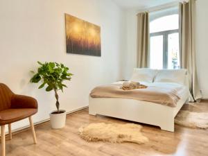 sypialnia z łóżkiem, krzesłem i rośliną w obiekcie Golden Deer Apartment - 3 Schlafzimmer - Zentrum - 92m² w Hanowerze
