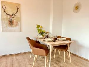 stół jadalny z krzesłami i obraz jelenia w obiekcie Golden Deer Apartment - 3 Schlafzimmer - Zentrum - 92m² w Hanowerze