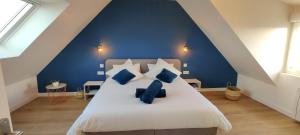- une chambre bleue avec un grand lit et des oreillers bleus dans l'établissement Maison wifi jardin arboré pointe du Raz, à Plogoff