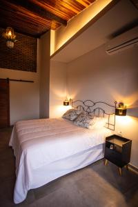 フェルナンド・デ・ノローニャにあるPousada Vila Nakauのベッドルーム1室(大きな白いベッド1台、照明2つ付)