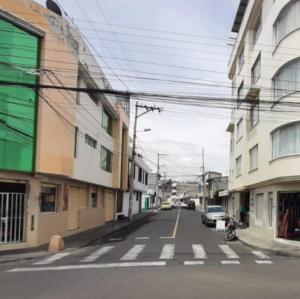 an empty city street with a car parked on the road at Mi casa in Latacunga