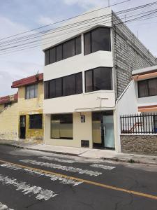 a white building on the side of a street at Mi casa in Latacunga