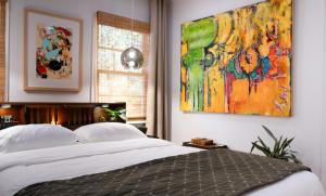 a bedroom with a bed and a painting on the wall at Art Haven: Immersive Art Stay in Denton