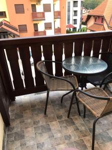 patio con mesa y sillas en el balcón en Jelen, en Zlatibor