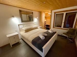 - une chambre avec un lit, un miroir et une chaise dans l'établissement Ski in-Ski out! Spacious & Stylish Apartment for 8 in the heart of Lavachet, à Tignes