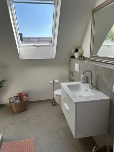 a bathroom with a sink and a toilet and a window at Licht+Luft, Wohnen auf Zeit in Bad Nauheim