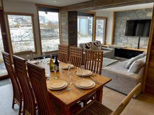 a dining room with a table and a couch at Ski in-Ski out! Spacious & Stylish Apartment for 8 in the heart of Lavachet in Tignes