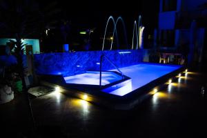 una piscina con luces en un patio trasero por la noche en EXCLUSIVE CONDO GALAPAGOS & BEYOND 2 en Puerto Ayora