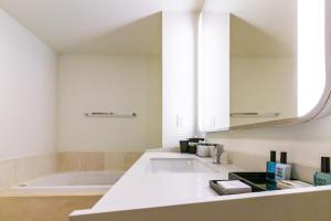 a bathroom with a sink and a bath tub at Fontainebleau in Miami Beach