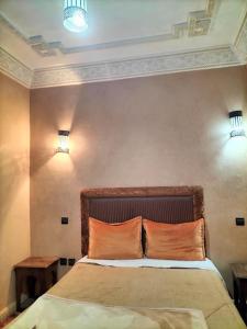 - une chambre avec un lit et deux oreillers orange dans l'établissement Gite Tizi Mizik, à Imlil