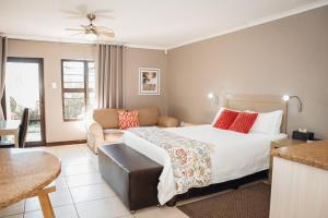 Habitación de hotel con cama y sofá en Perfek Stay Guesthouse, en Secunda