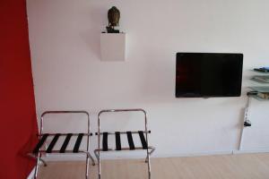Habitación con silla y TV en la pared. en MicroAppartment with bath and cozy balcony en Davos