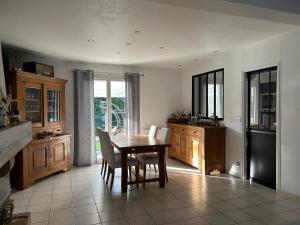 een keuken met een tafel en stoelen en een keuken met een raam bij Les Chopinettes in Saint-Prix