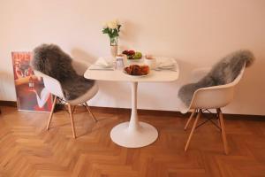 ein Tisch mit zwei Stühlen und ein Teller mit Essen drauf in der Unterkunft Cozy Flat in Piemonte in Acqui Terme