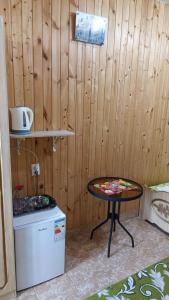 a small table in a room with a wooden wall at Orhidea guest house in Gagra
