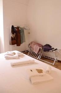 Zimmer mit einem Bett mit Handtüchern und einem Kinderbett in der Unterkunft Cozy Flat in Piemonte in Acqui Terme