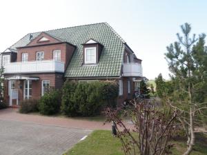 a red brick house with a green roof at Ferienwohnung Weitblick in Boltenhagen