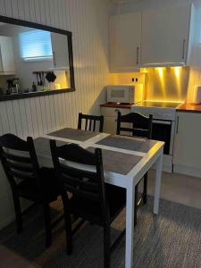 a kitchen with a white table and chairs and a table and a table at Gimle Casa in Tromsø