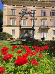 un edificio con un montón de flores rojas delante de él en Unique suite at Tenuta Granducale Dolciano, en Chiusi