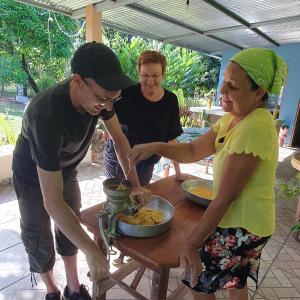 eine Gruppe von Menschen, die um einen Tisch stehen und Essen zubereiten in der Unterkunft Lodge LA EMBERÁ I Osez l'insolite tout confort 