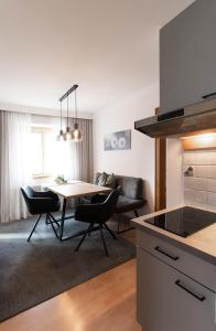 cocina y sala de estar con mesa y sillas en Faustlinghof, en Saalfelden am Steinernen Meer