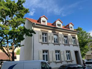 ein weißes Haus mit rotem Dach auf einer Straße in der Unterkunft CityDreams mit Altbau Flair in Lörrach