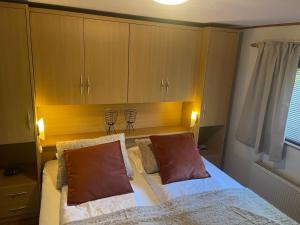 um quarto com uma cama com duas almofadas em Chalet Makkum V10 em Makkum
