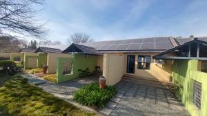 una casa con paneles solares en el techo en Perfek Stay Guesthouse, en Secunda