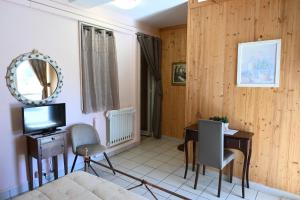 un soggiorno con letto, scrivania e TV di Residenza Relax dei Trulli ad Alberobello