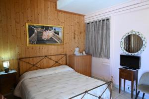 una camera con letto, specchio e TV di Residenza Relax dei Trulli ad Alberobello