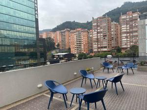 een groep tafels en stoelen op een balkon bij Aparta-estudio dotado para estrenar in Bogota