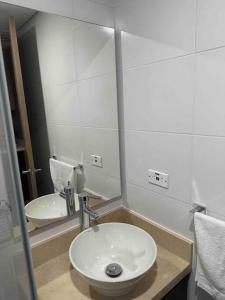 een badkamer met een wastafel en een spiegel bij Aparta-estudio dotado para estrenar in Bogota