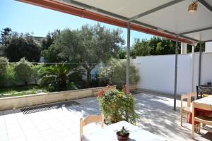un patio con tavoli, sedie e recinzione bianca di Residenza Relax dei Trulli ad Alberobello