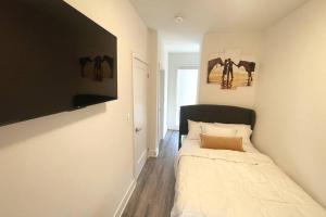 a bedroom with a bed and paintings on the wall at Exquisite, bright & modern condo. in Niagara Falls